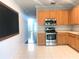 Bright kitchen featuring stainless steel appliances and light wood cabinetry with a view to the foyer at 10513 Leader Ln, Orlando, FL 32825