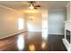 Bright living room featuring hardwood floors, a ceiling fan and a decorative fireplace at 10513 Leader Ln, Orlando, FL 32825