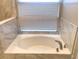 A bathtub with marble tile surround offers a relaxing retreat at 10969 Norcross Cir, Orlando, FL 32825