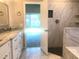 Renovated primary bath with a marble-tiled shower, granite countertops, and dual sinks at 10969 Norcross Cir, Orlando, FL 32825