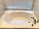A bathtub with marble tile surround offers a relaxing retreat at 10969 Norcross Cir, Orlando, FL 32825