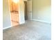 Bedroom leading to bath with carpeted floor, and neutral colored walls at 10969 Norcross Cir, Orlando, FL 32825