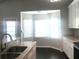 Kitchen featuring stone countertops, stainless sink, white cabinets, and bright nook with views to the yard at 10969 Norcross Cir, Orlando, FL 32825
