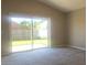 Well-lit living room featuring a sliding glass door that leads to the backyard at 10969 Norcross Cir, Orlando, FL 32825