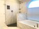 Beautifully updated walk-in shower and tub area with a marble tile surround at 10969 Norcross Cir, Orlando, FL 32825