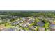 An aerial view of a suburban neighborhood with well-maintained homes, swimming pools and lush greenery around a pond at 1113 Fieldstone Cir, Oviedo, FL 32765
