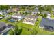 Aerial view of the backyard, featuring a patio and green lawn, near pools and a pond at 1113 Fieldstone Cir, Oviedo, FL 32765
