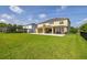 Expansive backyard featuring a spacious lawn, covered patio, and views of the surrounding neighborhood at 1113 Fieldstone Cir, Oviedo, FL 32765