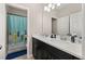 Bright bathroom featuring double sinks, black cabinets, and a shower with surfboard themed curtain at 1113 Fieldstone Cir, Oviedo, FL 32765