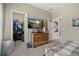 Bedroom with a wooden dresser and television with view to the closet and doorway at 1113 Fieldstone Cir, Oviedo, FL 32765