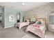 Bedroom featuring two twin beds, wallpaper accent wall, and ceiling fan at 1113 Fieldstone Cir, Oviedo, FL 32765