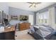 Comfortable bedroom with neutral walls, a ceiling fan, a wooden desk, and a window with plantation shutters at 1113 Fieldstone Cir, Oviedo, FL 32765