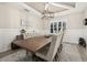 Bright dining room with a large wooden table, tufted bench seating, light walls, and a modern light fixture at 1113 Fieldstone Cir, Oviedo, FL 32765