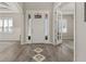 Welcoming entryway features a white front door with sidelights and modern rug on wood-look floors at 1113 Fieldstone Cir, Oviedo, FL 32765
