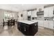 View of open kitchen with black island, stainless steel appliances, and adjacent breakfast nook at 1113 Fieldstone Cir, Oviedo, FL 32765