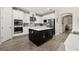 Bright kitchen with white cabinets, dark island, stainless appliances, and wood-look flooring at 1113 Fieldstone Cir, Oviedo, FL 32765