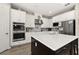 A kitchen boasts white cabinets, stainless appliances, a large island, and modern lighting at 1113 Fieldstone Cir, Oviedo, FL 32765