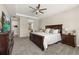 Main bedroom with large dresser, TV, neutral walls and carpet, and adjoining main bathroom at 1113 Fieldstone Cir, Oviedo, FL 32765