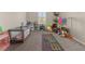 Spacious playroom with a colorful hopscotch rug, toddler bunkbed, and various toys at 1113 Fieldstone Cir, Oviedo, FL 32765
