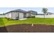 Well-maintained backyard featuring a patio, manicured lawn, mulch bed, and privacy fence at 1203 Pearl Tree Rd, Deltona, FL 32725