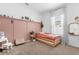 Charming bedroom featuring a trendy pink accent wall, natural light, and comfortable furnishings at 1203 Pearl Tree Rd, Deltona, FL 32725