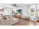 Bright living room with a large sectional sofa, modern media console, and a ceiling fan at 1203 Pearl Tree Rd, Deltona, FL 32725