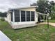 A well-maintained manufactured home featuring a sunny screened-in porch and convenient covered parking at 125 Darlene Ct, Davenport, FL 33897