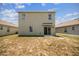 Exterior view of the back of a home, featuring windows and sliding glass doors to the backyard at 129 Eagleview Loop, Davenport, FL 33837