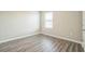 A cozy bedroom with a window, neutral walls, modern flooring, and base trim at 129 Eagleview Loop, Davenport, FL 33837