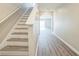 Hallway with staircase and doorway leading to bright, open living space with wood floors at 129 Eagleview Loop, Davenport, FL 33837