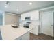 Bright kitchen features white cabinetry, stainless appliances, and a large center island at 129 Eagleview Loop, Davenport, FL 33837