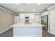 Bright kitchen features white cabinetry, stainless appliances, and a large center island at 129 Eagleview Loop, Davenport, FL 33837