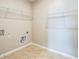 A functional laundry room with tile flooring, storage shelves, and neutral-toned walls at 129 Eagleview Loop, Davenport, FL 33837
