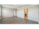 Spacious bedroom with wood-look flooring and view to the connected bathroom and walk-in closet at 129 Eagleview Loop, Davenport, FL 33837