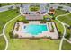 Aerial view of a community pool with lounge chairs and umbrellas surrounded by landscaping at 129 Eagleview Loop, Davenport, FL 33837