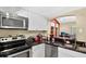 Well-lit kitchen featuring black countertops, stainless steel appliances, and white cabinetry at 1321 Arbor Vista Loop # 301, Lake Mary, FL 32746