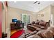Open-concept living room features a leather sofa, desk, and sliding glass doors at 1321 Arbor Vista Loop # 301, Lake Mary, FL 32746