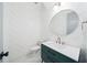 Modern bathroom with a green vanity, round mirror, herringbone accent wall, and stylish fixtures at 1414 W New Hampshire St, Orlando, FL 32804