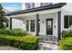 Inviting front porch with decorative columns, lush landscaping, and a stylish front door at 1414 at 1414 W New Hampshire St, Orlando, FL 32804