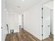 Well-lit hallway featuring hardwood floors, neutral paint, and doorways leading to various rooms at 1414 W New Hampshire St, Orlando, FL 32804