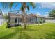 Expansive, well-maintained backyard featuring a screened-in pool area and lush green lawn under a clear sky at 14306 Paradise Tree Dr, Orlando, FL 32828