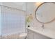 Updated bathroom featuring a vanity, round mirror, and shower/tub combination with a modern shower curtain at 14306 Paradise Tree Dr, Orlando, FL 32828