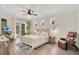 Cozy bedroom featuring neutral walls, ceiling fan, hardwood floors, and natural light at 14306 Paradise Tree Dr, Orlando, FL 32828