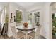 Bright breakfast nook with round table, white chairs, and views of the backyard pool at 14306 Paradise Tree Dr, Orlando, FL 32828