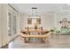 Dining room features wooden table and bench seating with modern lighting fixture at 14306 Paradise Tree Dr, Orlando, FL 32828