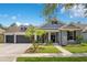 Charming one-story home with landscaped front yard, gray paint, black shutters, and a spacious three-car garage at 14306 Paradise Tree Dr, Orlando, FL 32828