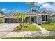 Charming one-story home with landscaped front yard, gray paint, black shutters, and a spacious three-car garage at 14306 Paradise Tree Dr, Orlando, FL 32828