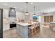 Modern kitchen with white cabinets, gray island, pendant lights, stainless steel appliances, and hardwood floors at 14306 Paradise Tree Dr, Orlando, FL 32828