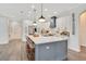 Elegant kitchen with an island, white cabinets, stainless steel appliances, and stylish pendant lights at 14306 Paradise Tree Dr, Orlando, FL 32828