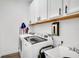 Well-equipped laundry room with modern washer and dryer, ample cabinet space, and utility sink for convenience at 14306 Paradise Tree Dr, Orlando, FL 32828